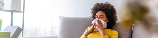 Woman Sneezing into a tissue